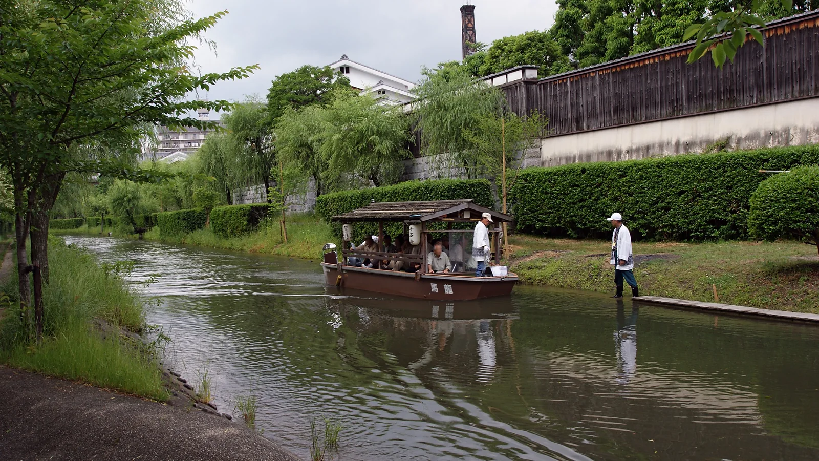 Traditional jikkokubune boat traveling along a canal in Fushimi, Kyoto