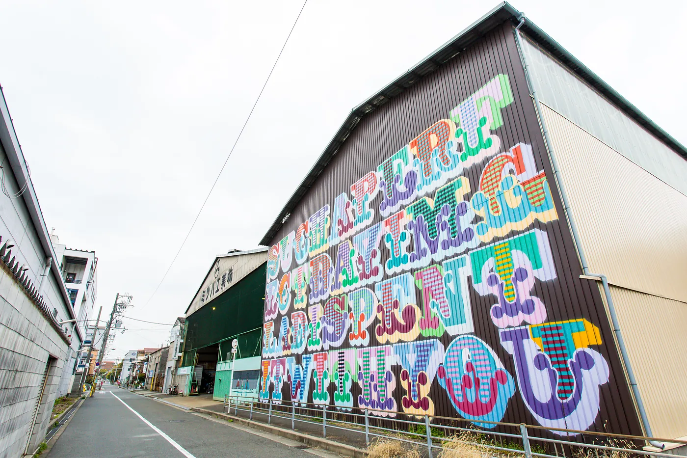 Large colorful street art mural on a warehouse wall in Kitakagaya, Osaka