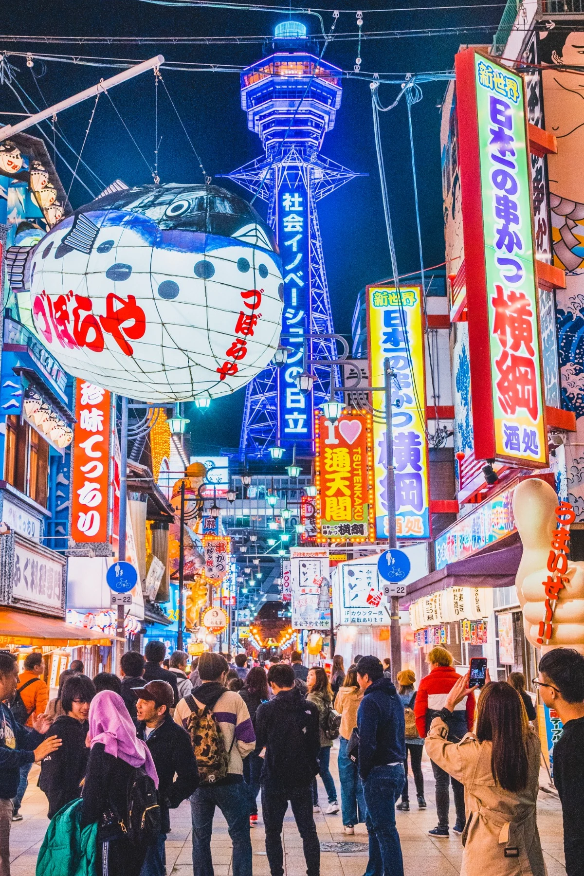 Tsutenkaku Tower and illuminated restaurant signs in Shinsekai, Osaka at night
