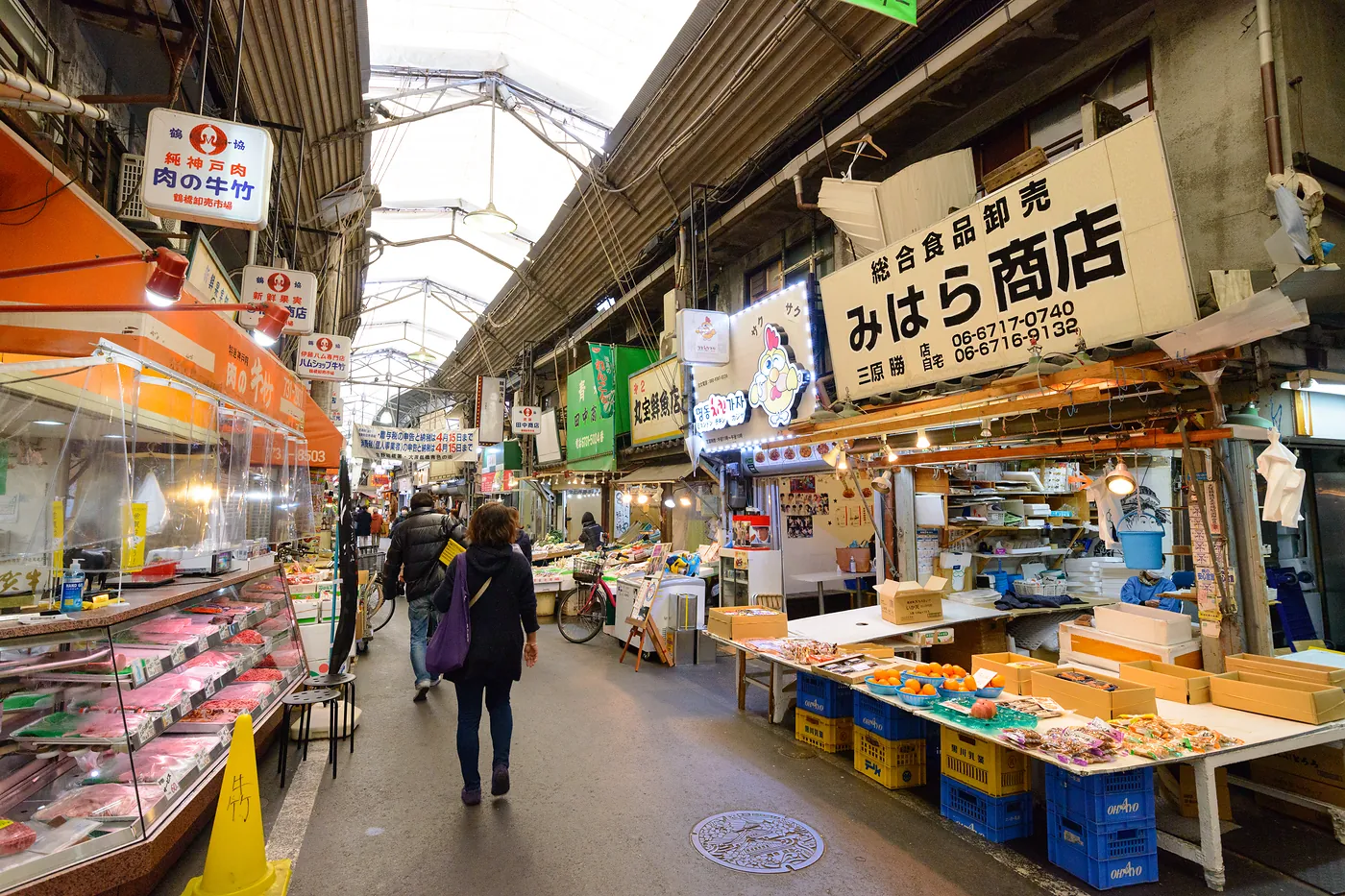 Tsuruhashi Market arcade in Osaka with food stalls, shop signs and shoppers