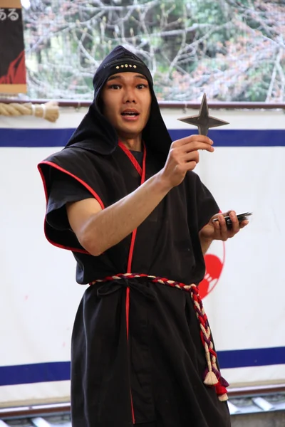 Ninja performer holding a shuriken during a ninja show in Iga Ueno