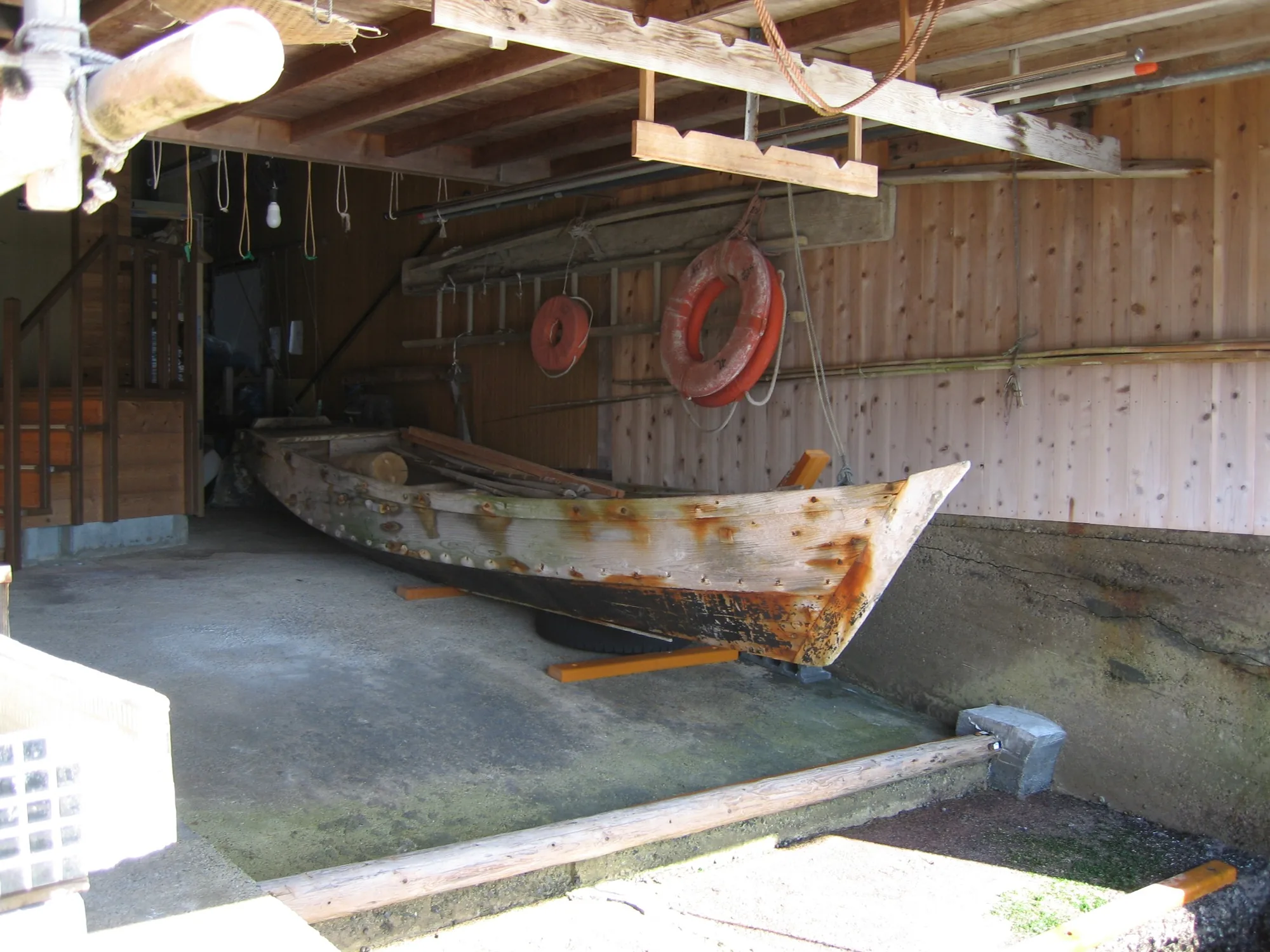 Traditional wooden boat stored inside a funaya boathouse in Ine