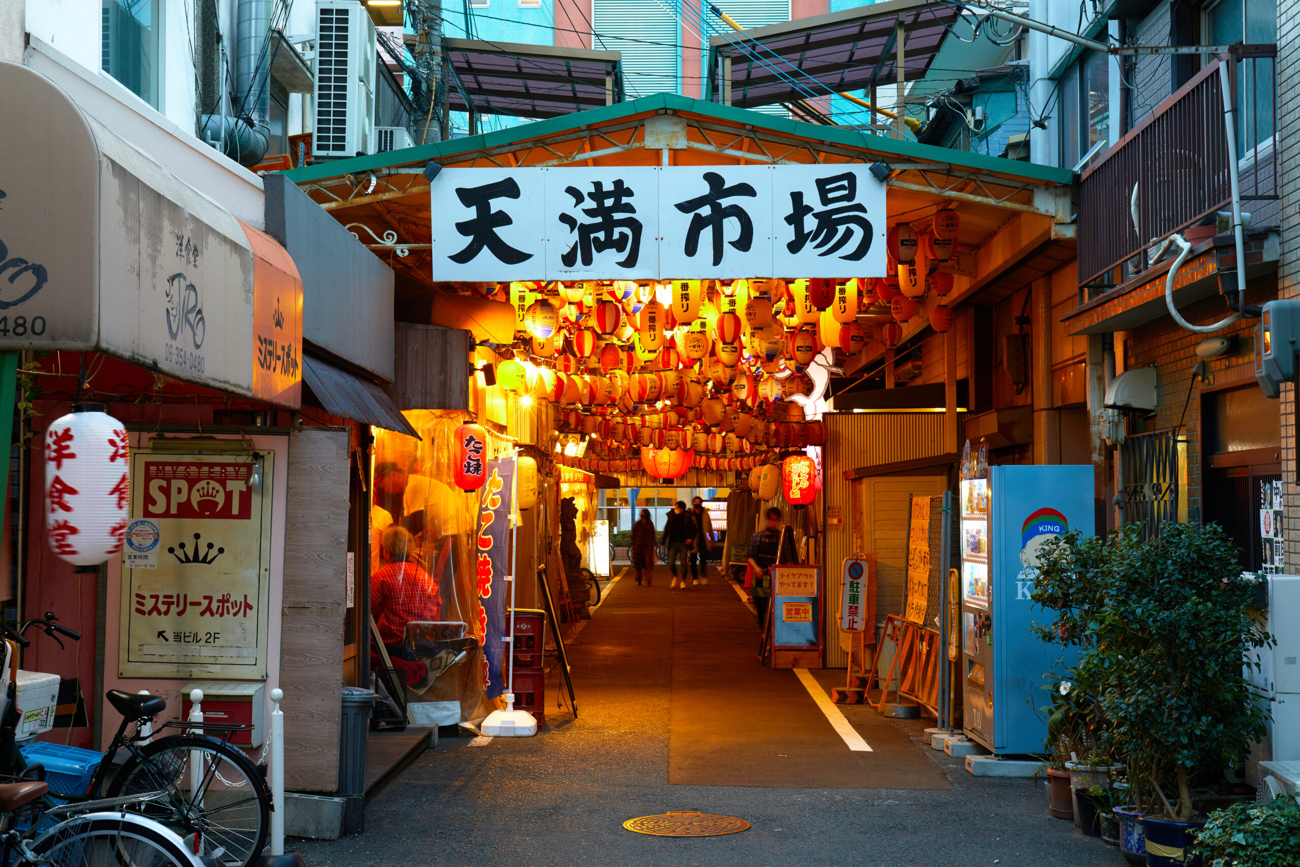Lantern-lit Tenma Market entrance in Osaka at dusk